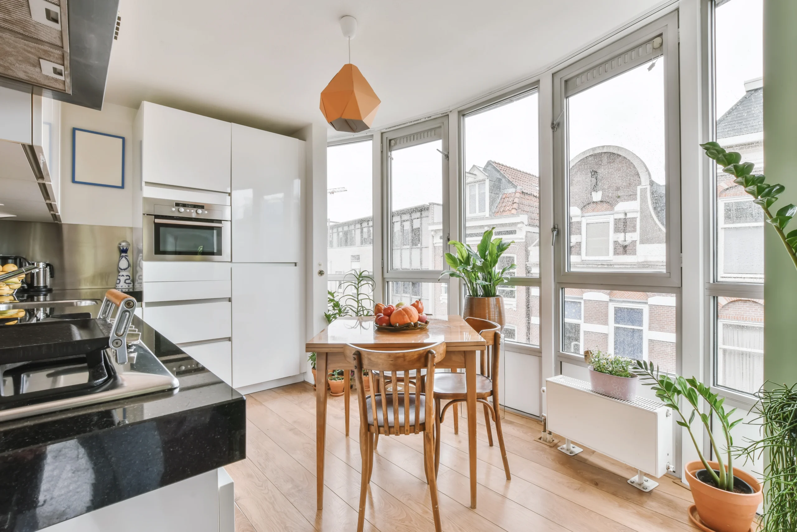 Sunlight streams through large windows in this kitchen/dining area, featuring professional window installation Covington WA.
