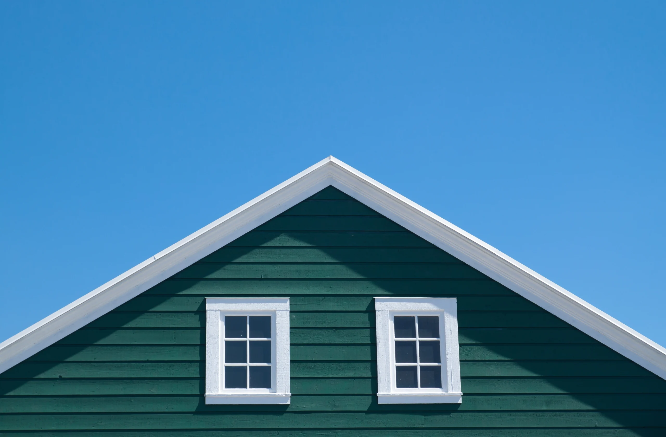 Green house siding and white roof trim completed by a professional General Contractor Covington WA.