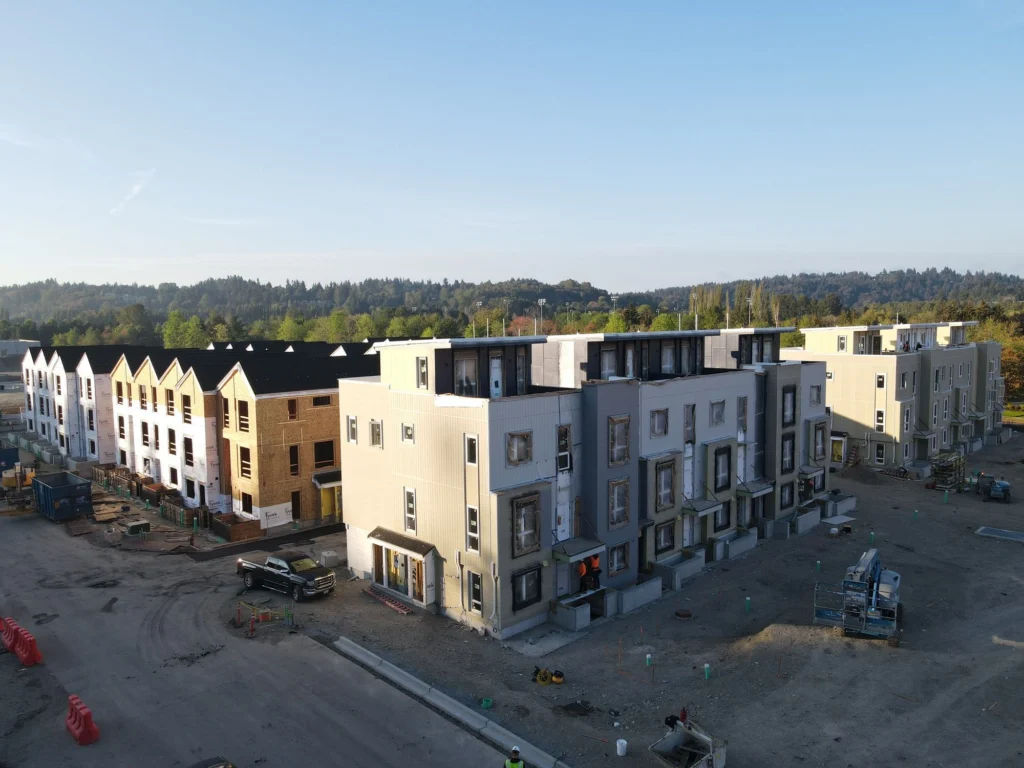 Large new multi-family development with modern buildings, parking lot, and landscaping by Multi Family Exterior Contractor Bothell.